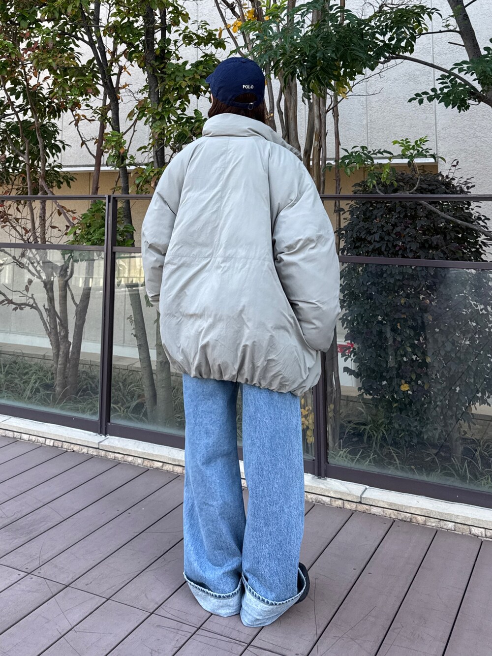 ベージュ系のブルゾン、グレー系のスウェット、ブルー系のデニムパンツを着用したレディースの冬コーディネートの3枚目の写真