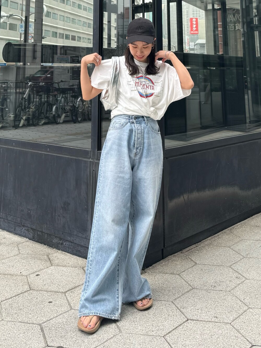 ブルー系のデニムパンツ、ホワイト系のTシャツ/カットソー、シルバー系のハンドバッグを着用したレディースの春コーディネートの2枚目の写真