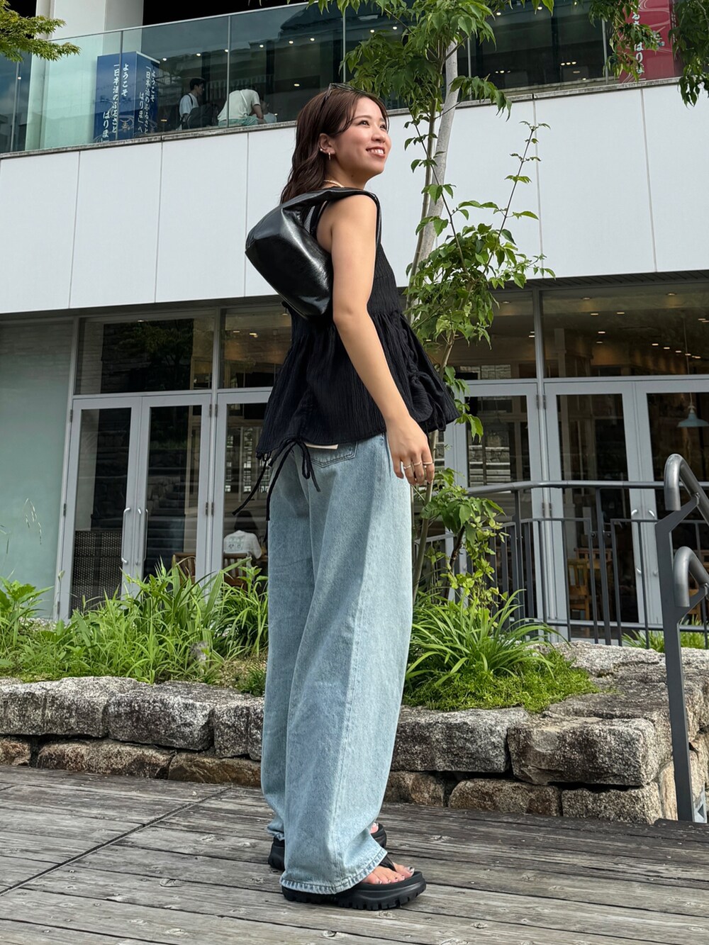 グレー系のタンクトップ、ブラック系のシャツ/ブラウス、ブルー系のデニムパンツを着用したレディースの夏コーディネートの5枚目の写真