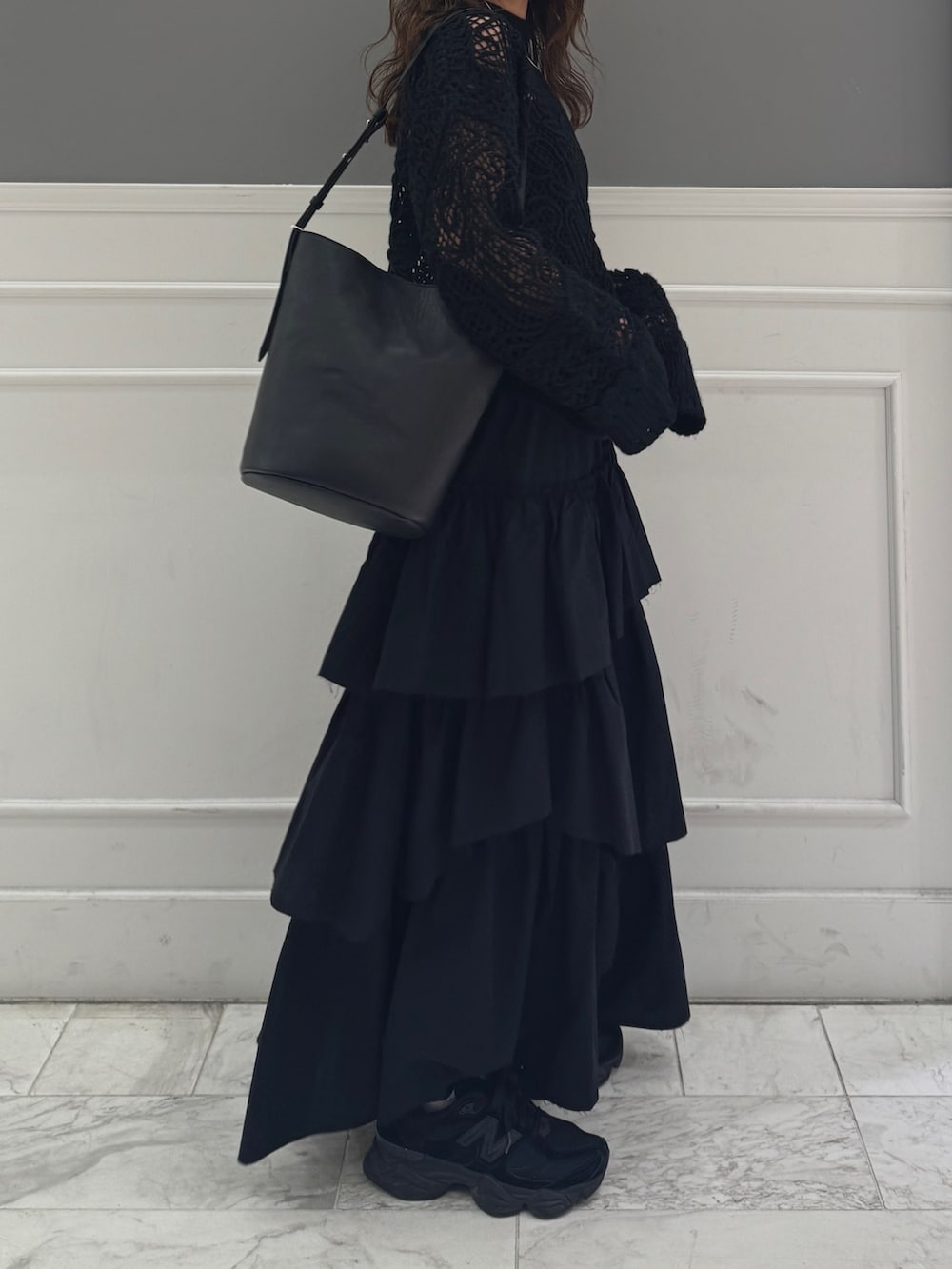 ブラック系のスカート、ブラック系のニット/セーター、ブラック系のショルダーバッグを着用したレディースの冬コーディネートの6枚目の写真