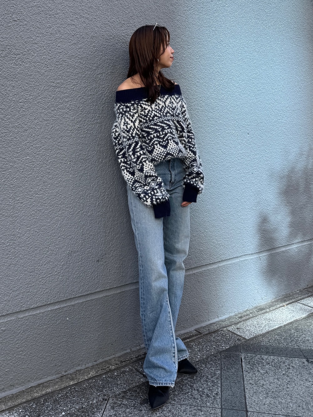ブルー系のニット/セーター、ブルー系のデニムパンツを着用したレディースの秋コーディネートの8枚目の写真