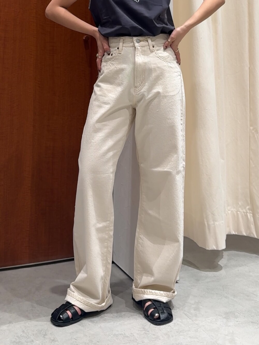 ホワイト系のデニムパンツ、グレー系のタンクトップ、ブラック系のサンダルを着用したレディースの春コーディネートの10枚目の写真