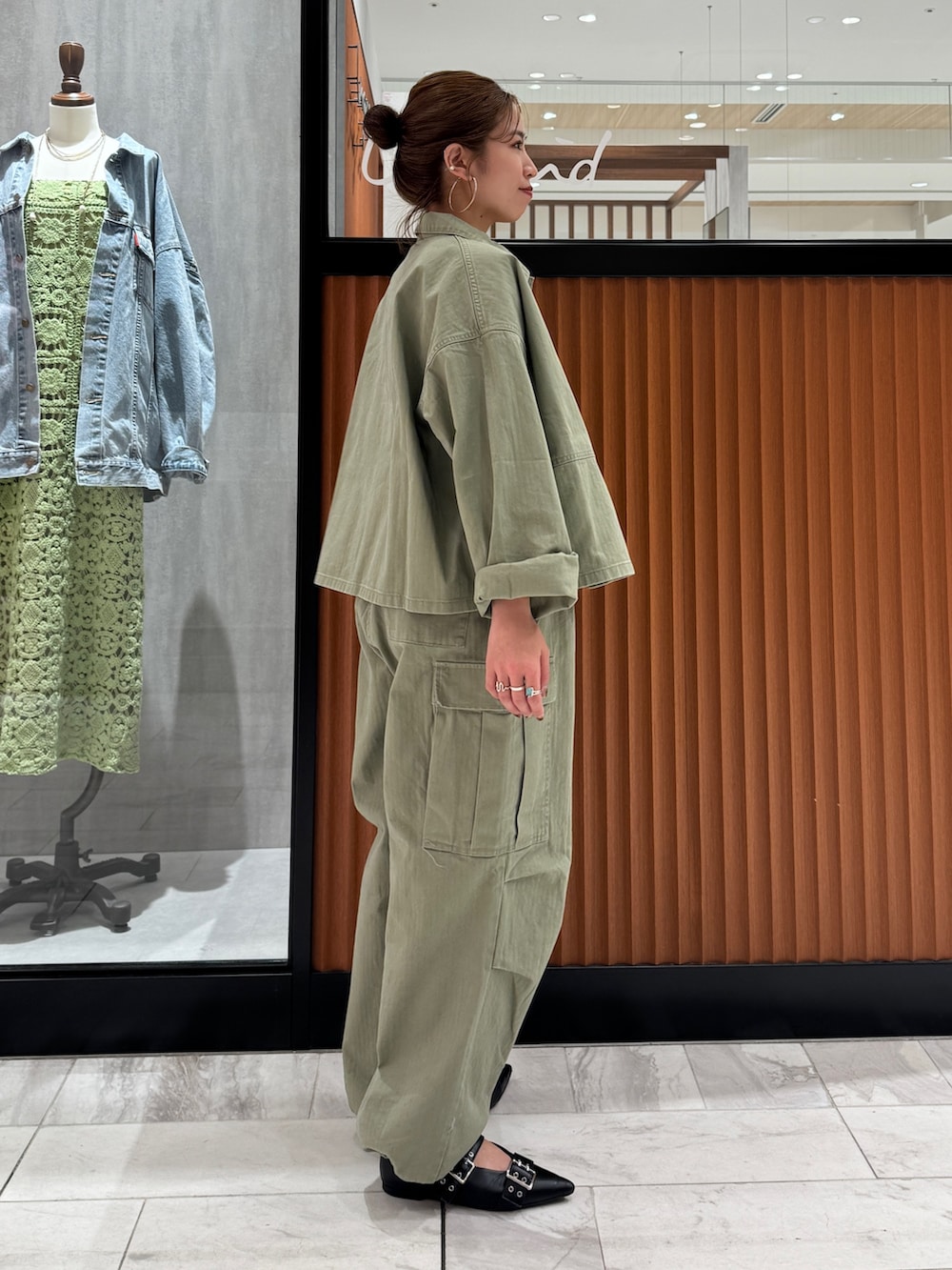 グリーン系のミリタリージャケット、ブラック系のキャミソール、グリーン系のその他パンツを着用したレディースの春コーディネートの3枚目の写真