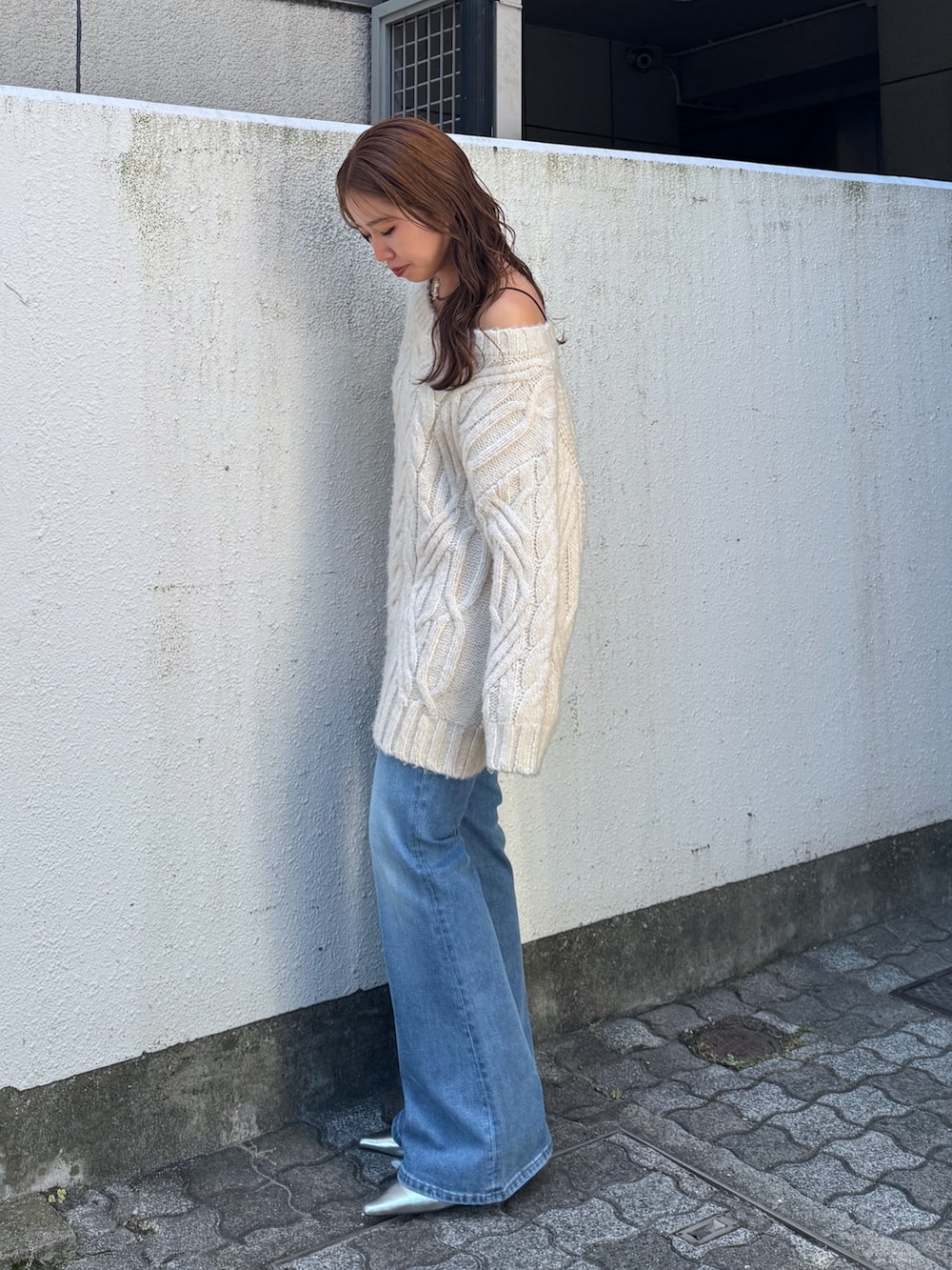 ホワイト系のニット/セーター、ブルー系のデニムパンツ、シルバー系のその他シューズを着用したレディースの夏コーディネートの3枚目の写真