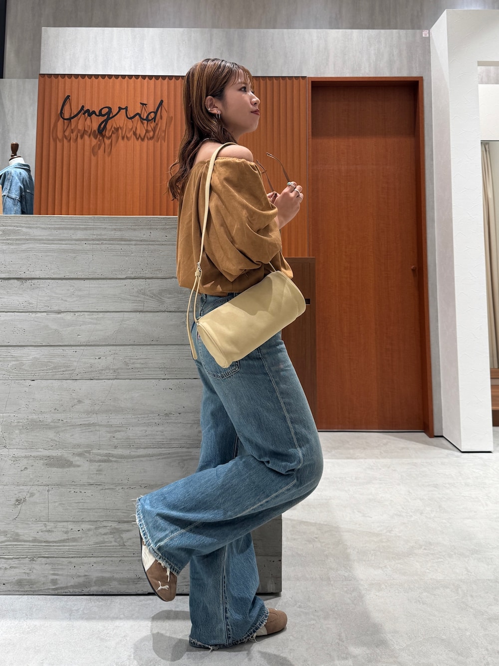 ブルー系のデニムパンツ、イエロー系のシャツ/ブラウス、ブラウン系のサングラスを着用したレディースの夏コーディネートの5枚目の写真