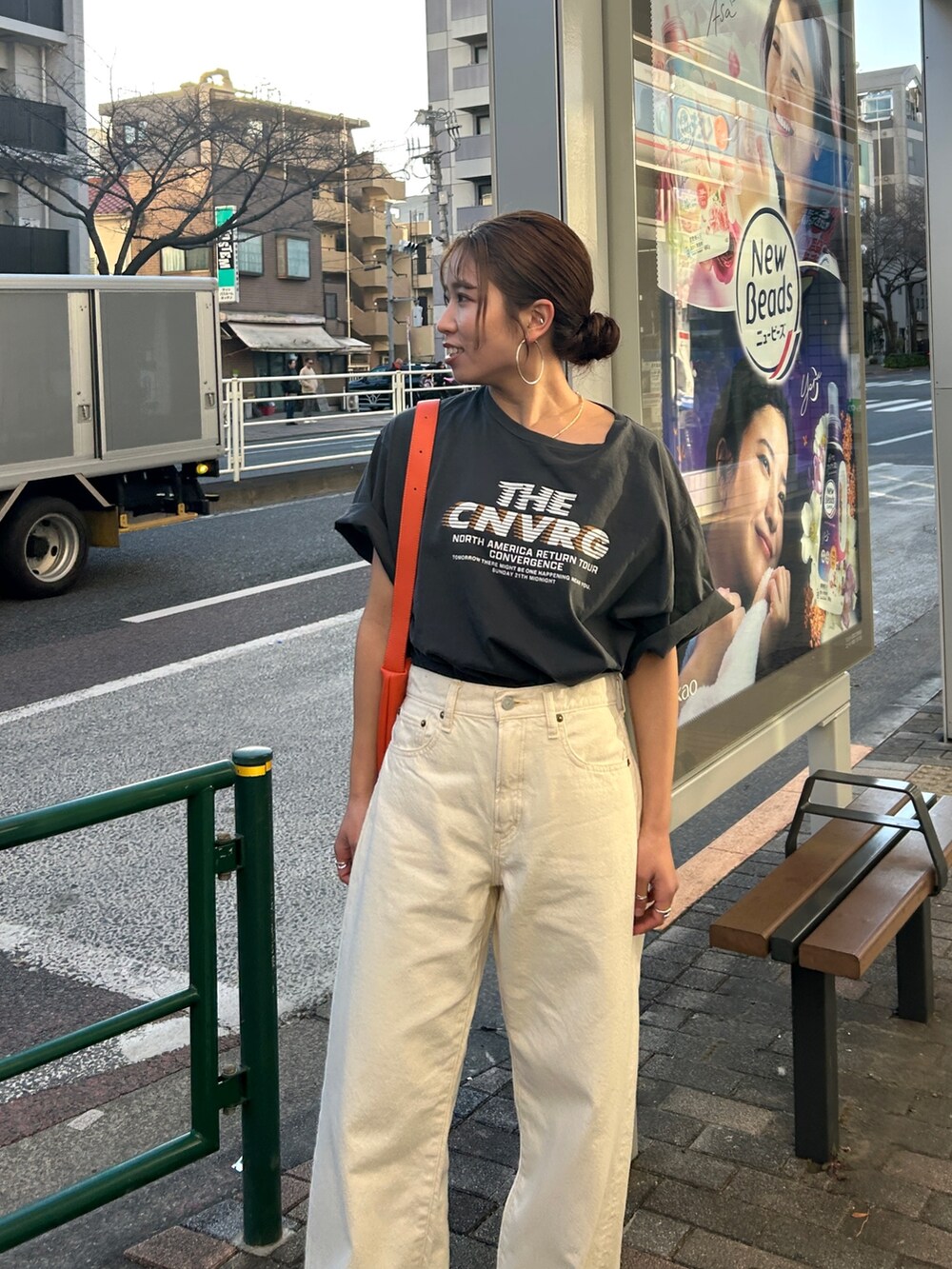 グレー系のTシャツ/カットソー、ホワイト系のデニムパンツ、オレンジ系のショルダーバッグを着用したレディースの春コーディネートの4枚目の写真