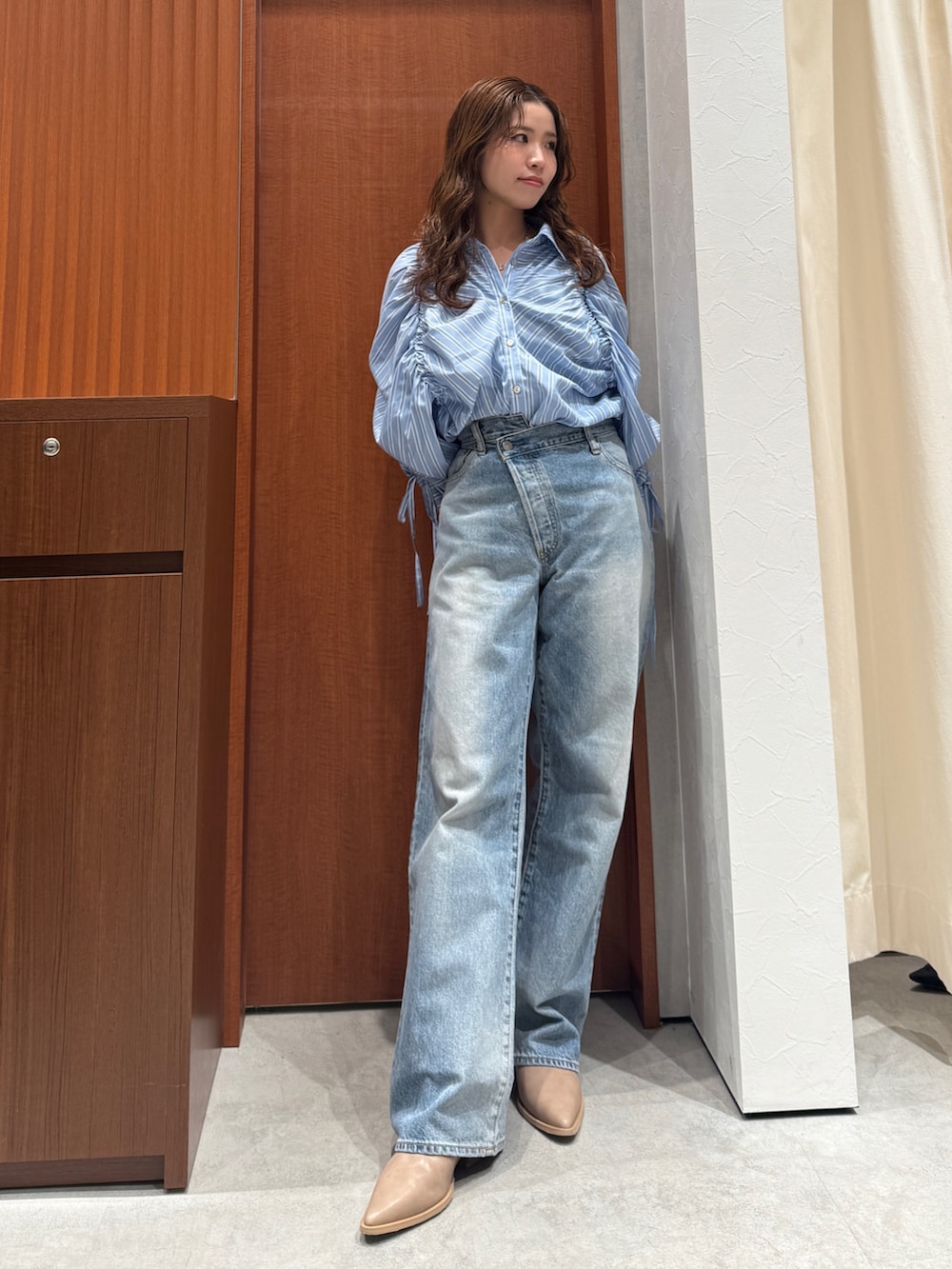 ブルー系のシャツ/ブラウス、ブルー系のデニムパンツ、ベージュ系のブーツを着用したレディースの春コーディネートの2枚目の写真