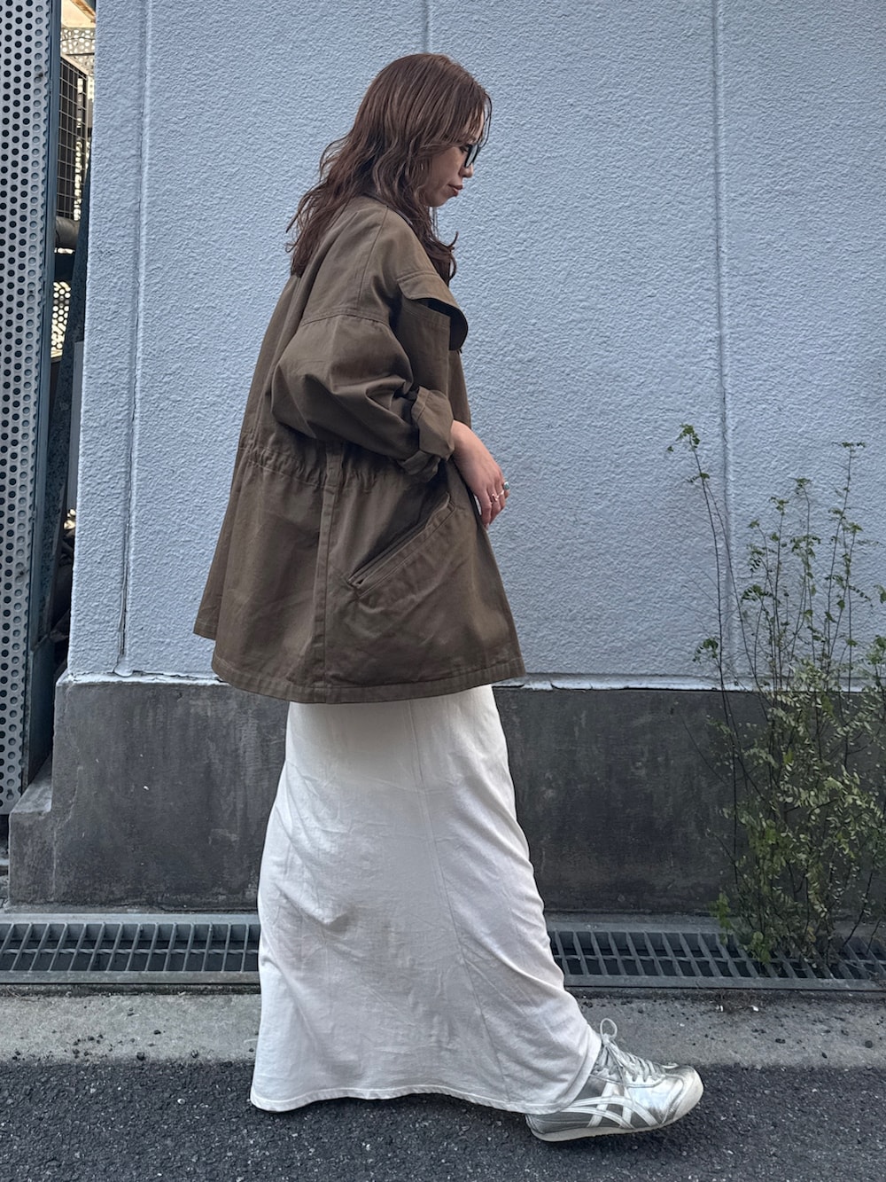 ホワイト系のスカート、ブラウン系のブルゾン、グリーン系のスウェットを着用したレディースの冬コーディネートの3枚目の写真