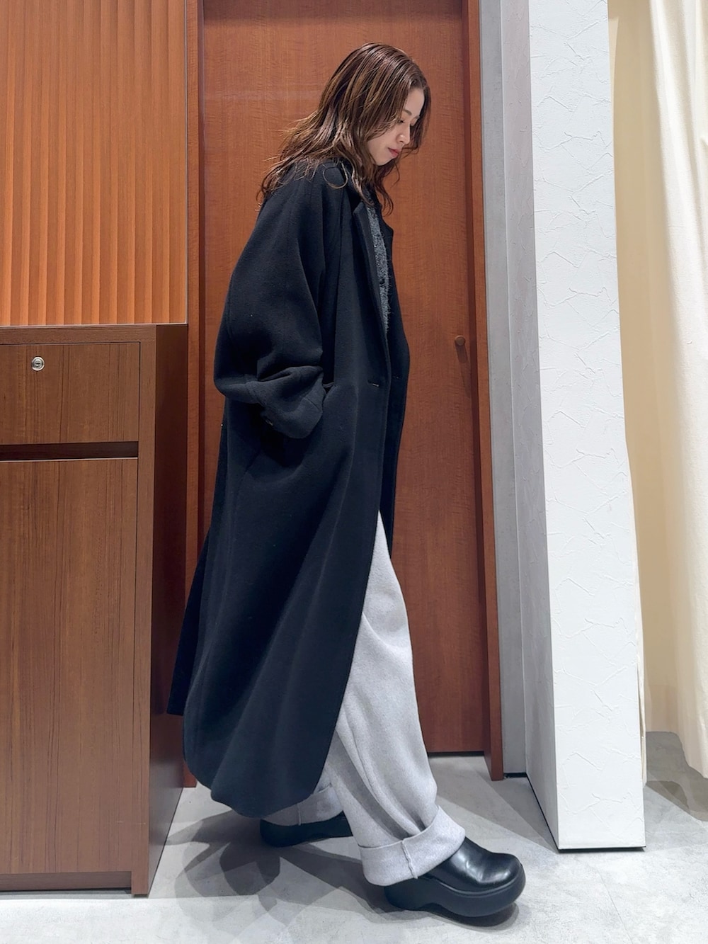 グレー系のカーディガン/ボレロ、グレー系のその他パンツ、ブラック系のチェスターコートを着用したレディースの冬コーディネートの3枚目の写真