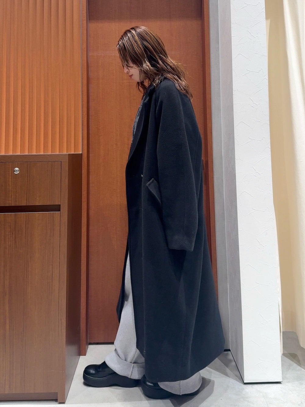 グレー系のカーディガン/ボレロ、グレー系のその他パンツ、ブラック系のチェスターコートを着用したレディースの冬コーディネートの7枚目の写真