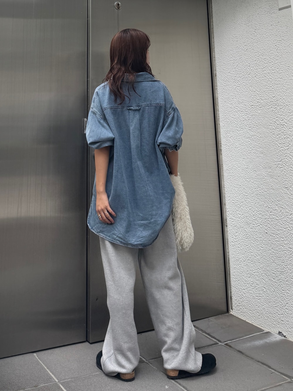 ブルー系のシャツ/ブラウス、ホワイト系のハンドバッグ、グレー系のその他パンツを着用したレディースの秋コーディネートの4枚目の写真