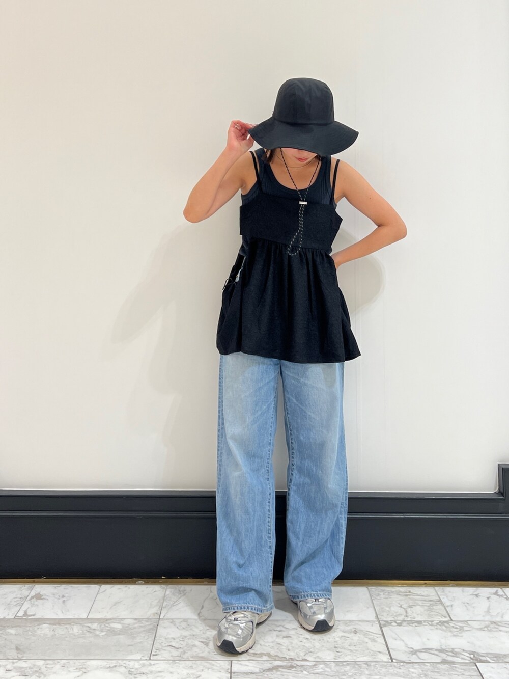 グレー系のタンクトップ、ブルー系のデニムパンツ、ブラック系のシャツ/ブラウスを着用したレディースの春コーディネートの7枚目の写真