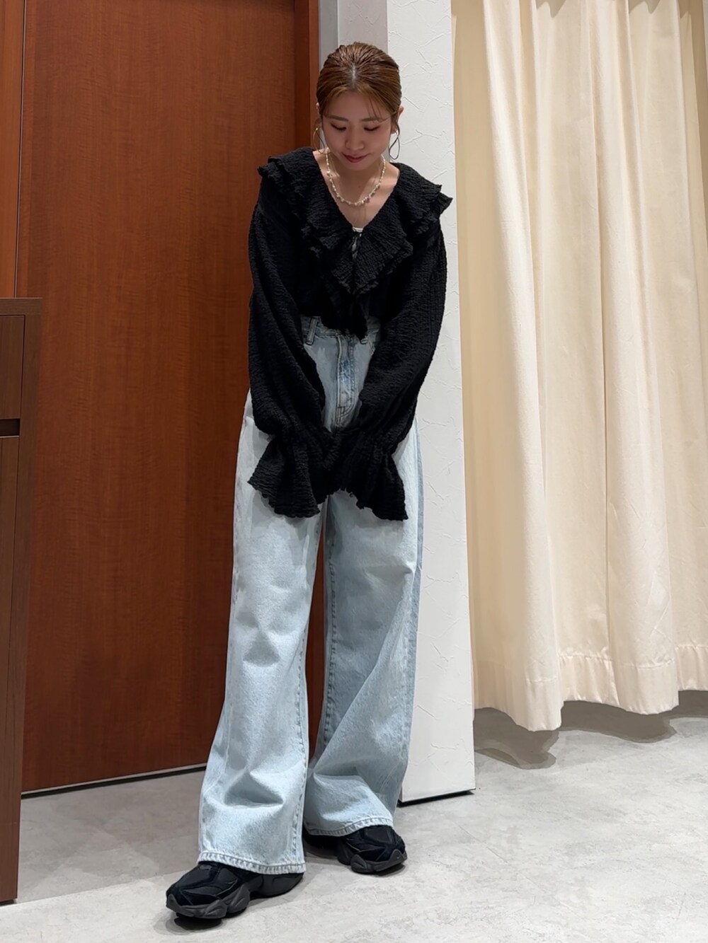 ブラック系のシャツ/ブラウス、ブルー系のデニムパンツを着用したレディースの春コーディネートの6枚目の写真