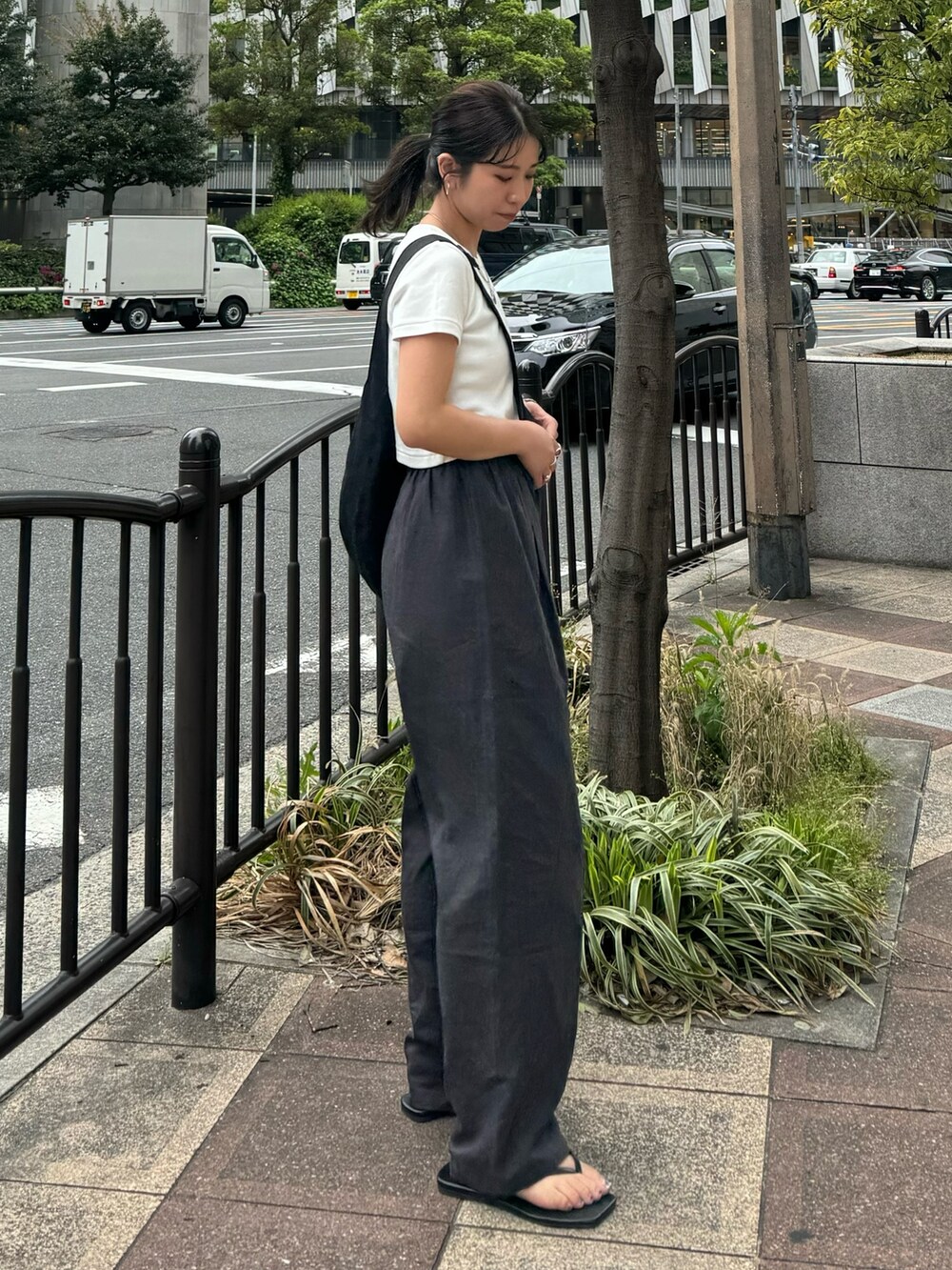 ホワイト系のTシャツ/カットソー、グレー系のその他パンツ、ブラック系のサンダルを着用したレディースの春コーディネートの4枚目の写真