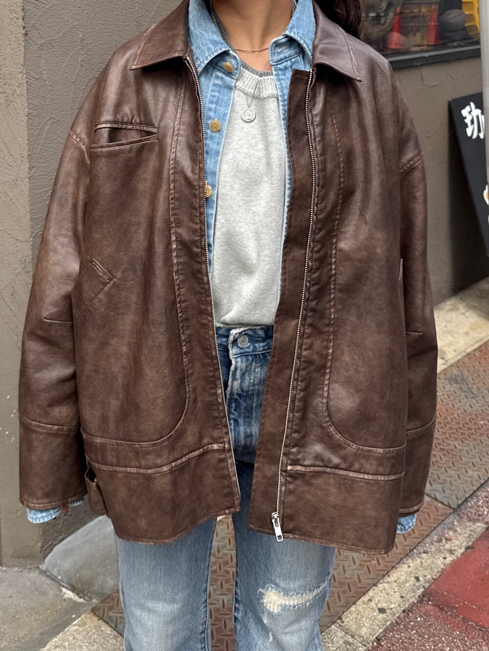 ブルー系のデニムパンツ、ブラウン系のブルゾン、ブルー系のシャツ/ブラウスを着用したレディースの冬コーディネートの5枚目の写真
