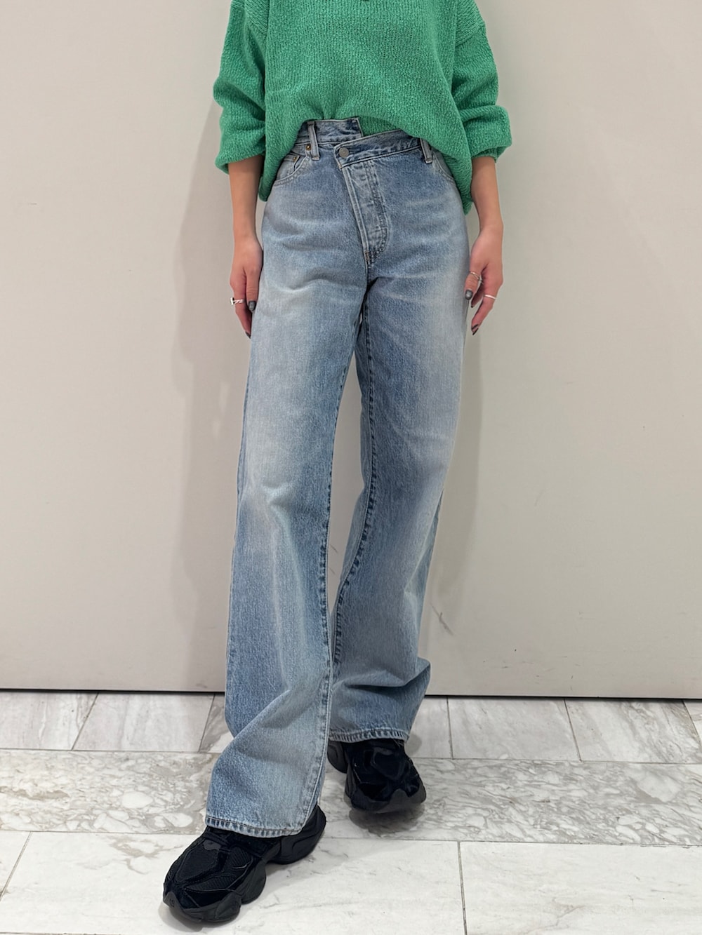 ブルー系のデニムパンツ、グリーン系のニット/セーター、シルバー系のネックレスを着用したレディースの冬コーディネートの7枚目の写真