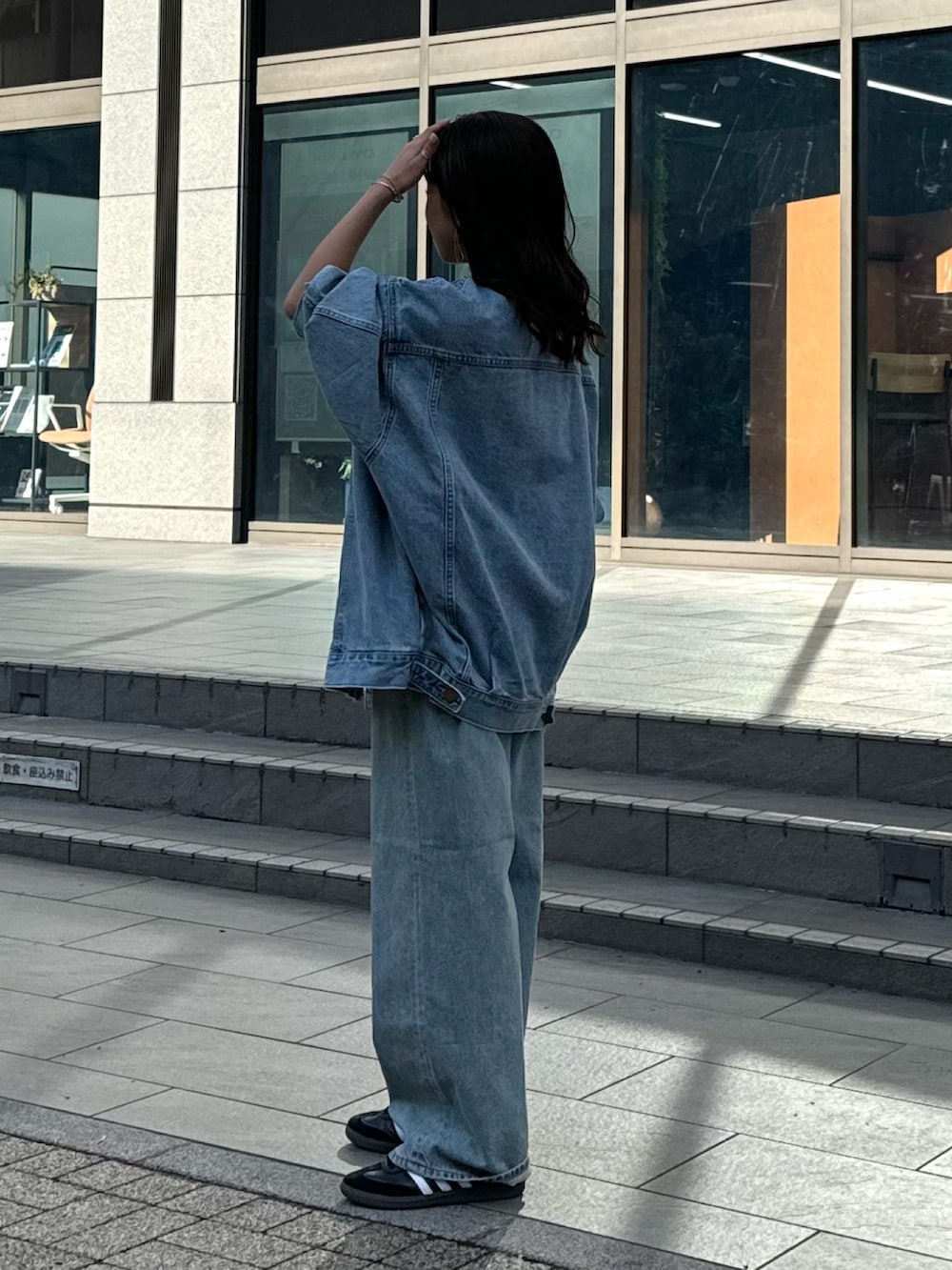 ブルー系のデニムパンツ、ブラック系のベスト、ホワイト系のTシャツ/カットソーを着用したレディースの冬コーディネートの8枚目の写真