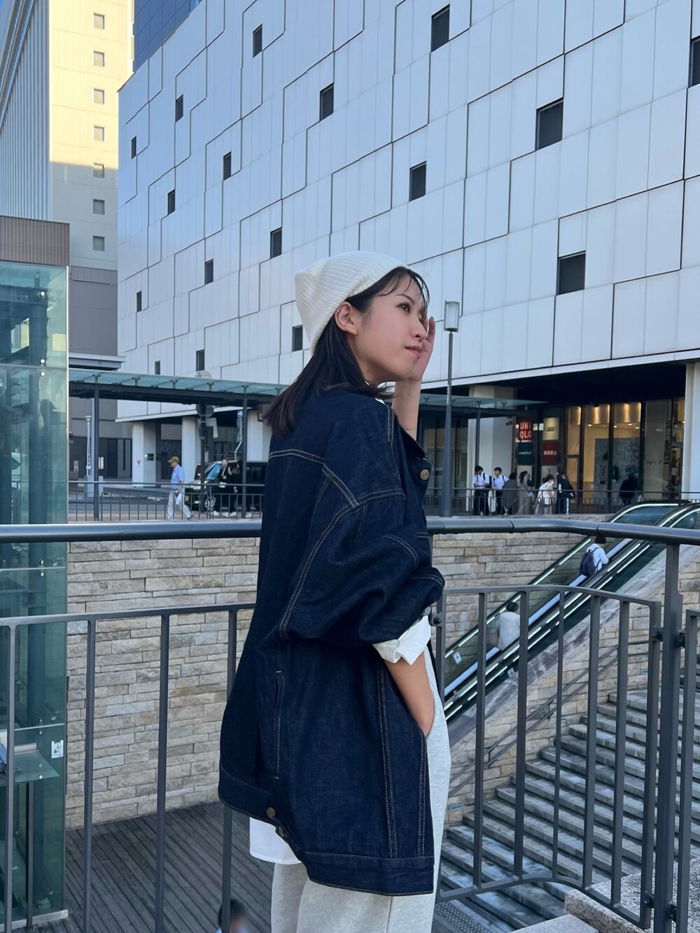 グレー系のスウェットパンツ、ブルー系のデニムジャケット、ブラック系のキャミソールを着用したレディースの秋コーディネートの5枚目の写真