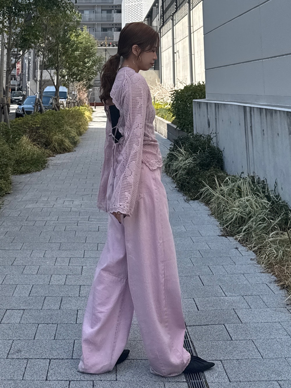 ピンク系のデニムパンツ、ピンク系のニット/セーター、ブラック系のパンプスを着用したレディースの春コーディネートの4枚目の写真