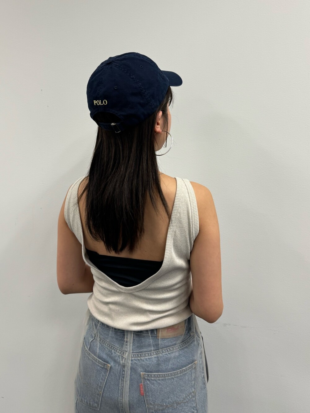 ブルー系のデニムパンツ、ベージュ系のその他パンツ、ホワイト系のタンクトップを着用したレディースの春コーディネートの4枚目の写真