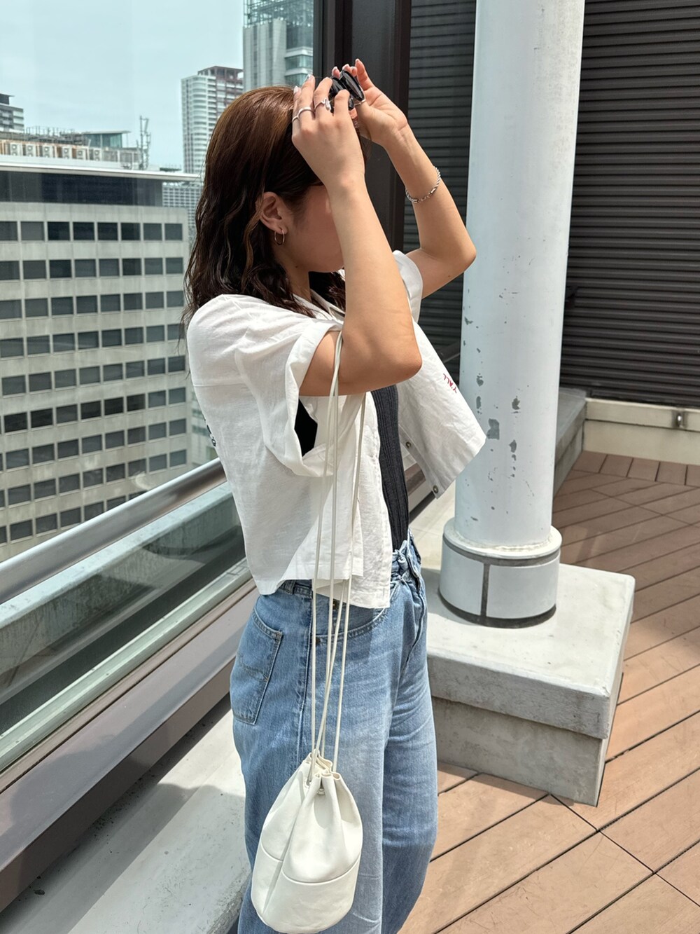 ブルー系のデニムパンツ、グレー系のTシャツ/カットソー、ホワイト系のシャツ/ブラウスを着用したレディースの夏コーディネートの6枚目の写真