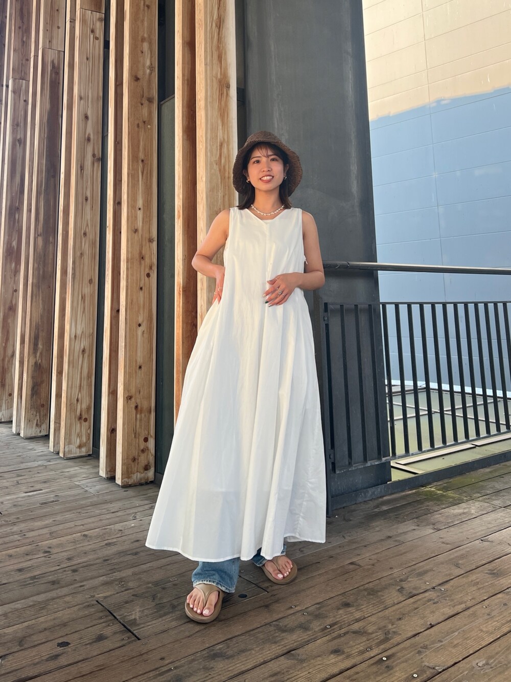 ホワイト系のワンピース、ブルー系のデニムパンツ、ブラウン系のハットを着用したレディースの夏コーディネートの7枚目の写真