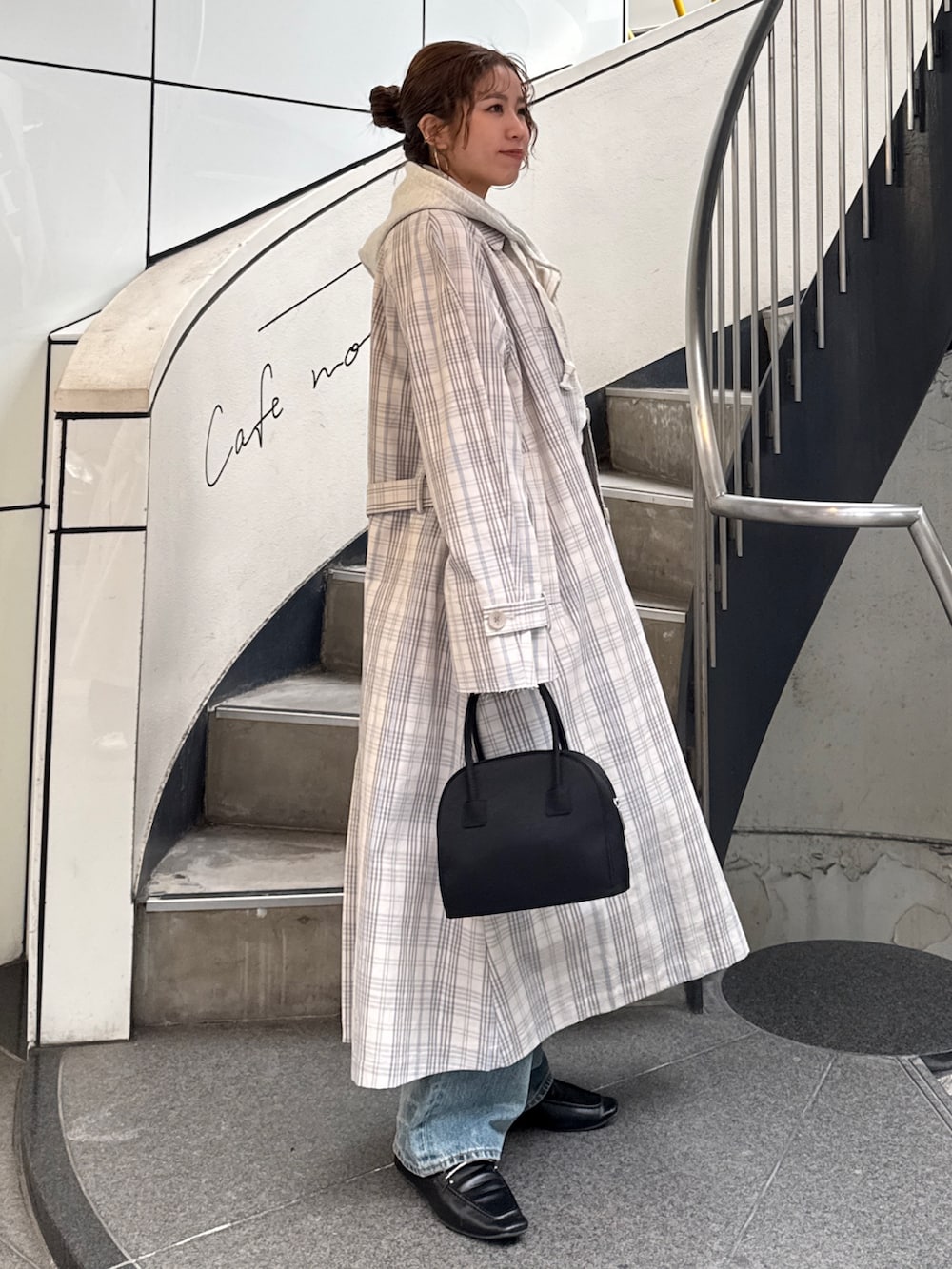 その他のステンカラーコート、ブラック系のボストンバッグ、ホワイト系のパーカーを着用したレディースの冬コーディネートの3枚目の写真