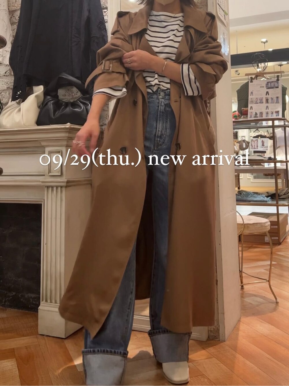 ブルー系のTシャツ/カットソー、イエロー系のトレンチコート、ホワイト系のブーツを着用したレディースの秋コーディネートの2枚目の写真