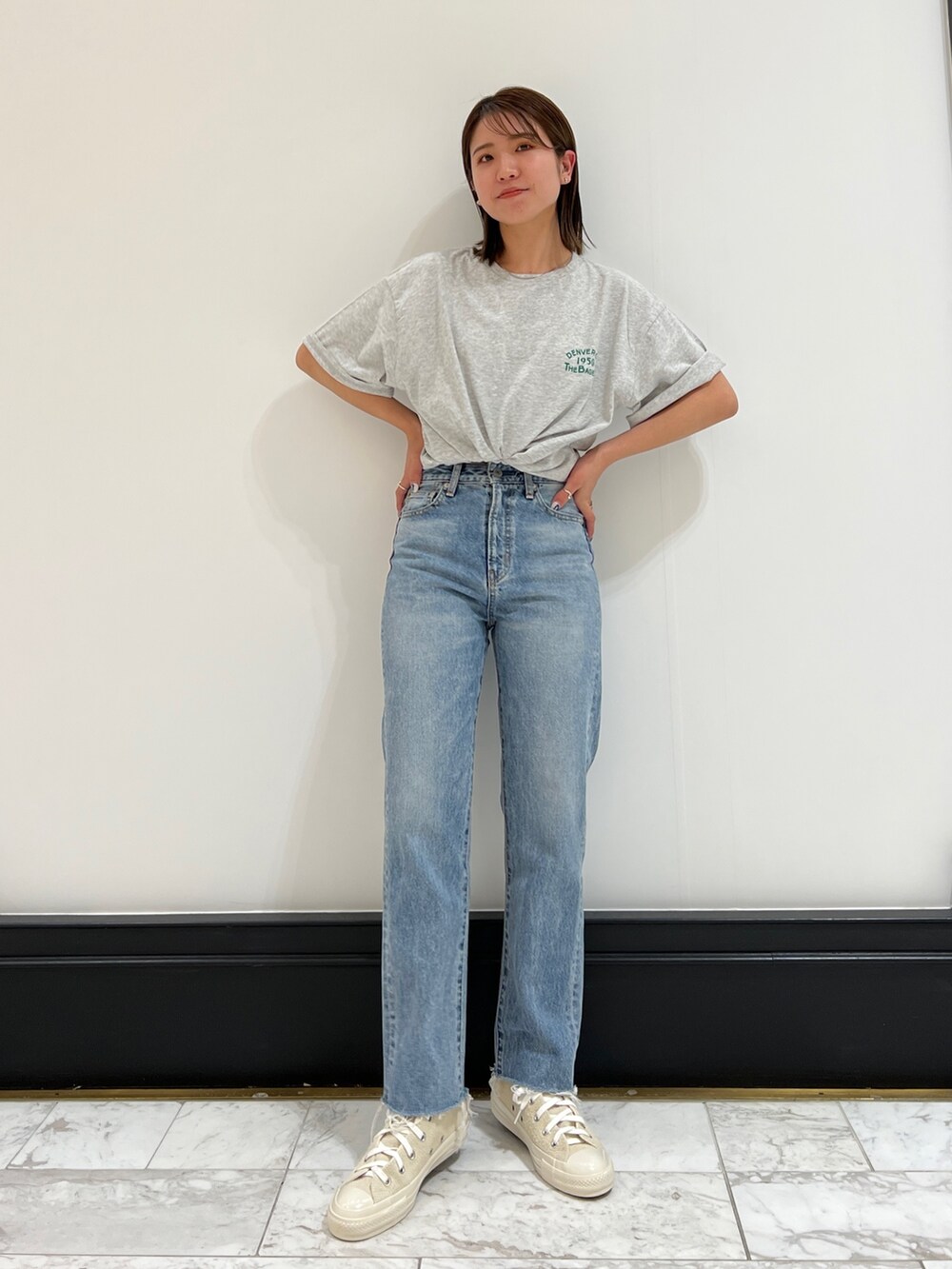 ブルー系のデニムパンツ、グレー系のTシャツ/カットソー、ホワイト系のスニーカーを着用したレディースの春コーディネートの7枚目の写真