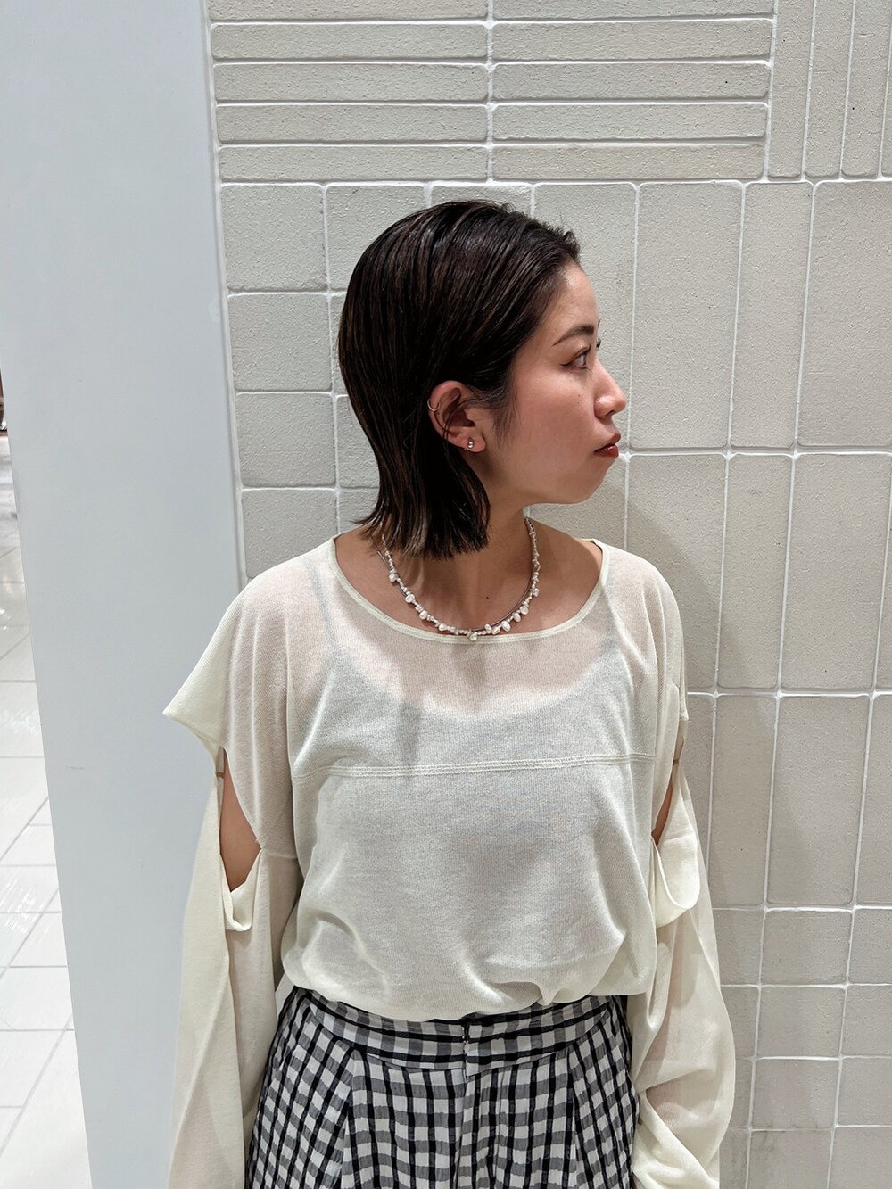 イエロー系のニット/セーター、イエロー系のパンプス、グレー系のその他パンツを着用したレディースの冬コーディネートの9枚目の写真