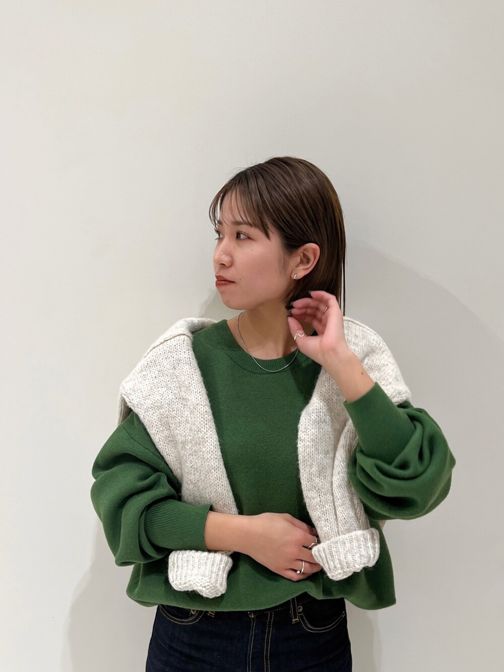 グリーン系のニット/セーター、ホワイト系のニット/セーターを着用したレディースの冬コーディネートの5枚目の写真