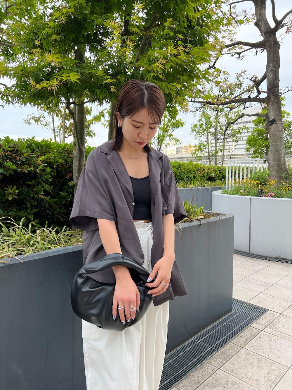 グレー系のシャツ/ブラウス、ブラック系のキャミソール、ホワイト系のカーゴパンツを着用したレディースの春コーディネートの4枚目の写真