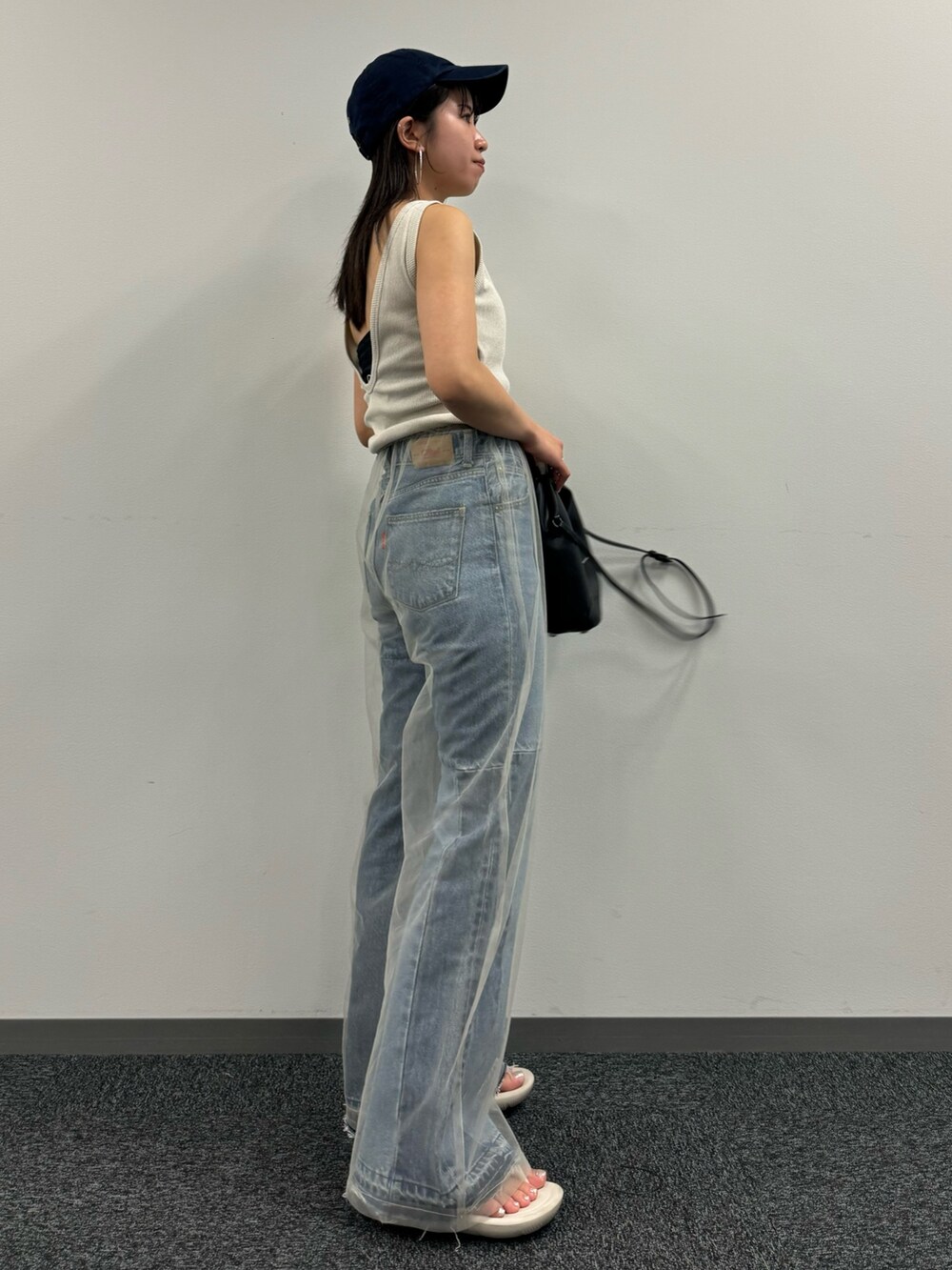 ブルー系のデニムパンツ、ベージュ系のその他パンツ、ホワイト系のタンクトップを着用したレディースの春コーディネートの6枚目の写真