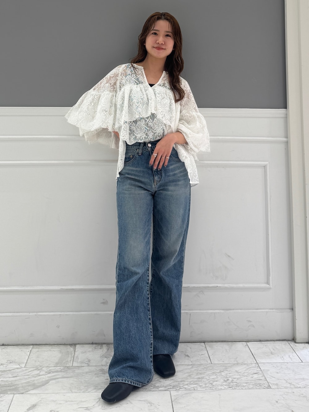 ブルー系のデニムパンツ、ホワイト系のシャツ/ブラウス、ブラック系のサンダルを着用したレディースの春コーディネートの4枚目の写真