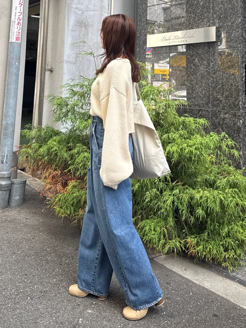 ブルー系のデニムパンツ、ホワイト系のニット/セーターを着用したレディースの秋コーディネートの3枚目の写真