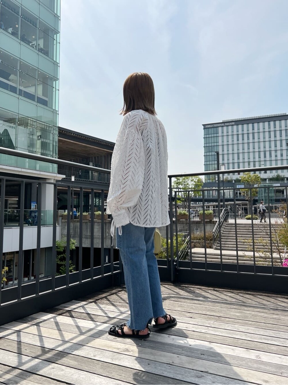 ホワイト系のシャツ/ブラウス、ブルー系のデニムパンツを着用したレディースの春コーディネートの4枚目の写真