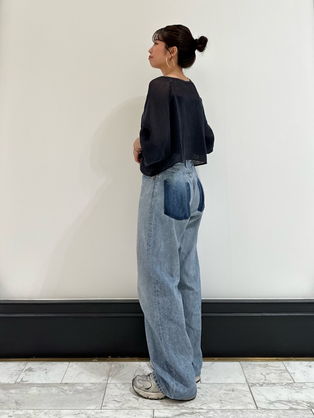 ブラック系のキャミソール、グレー系のTシャツ/カットソー、ブルー系のデニムパンツを着用したレディースの春コーディネートの2枚目の写真