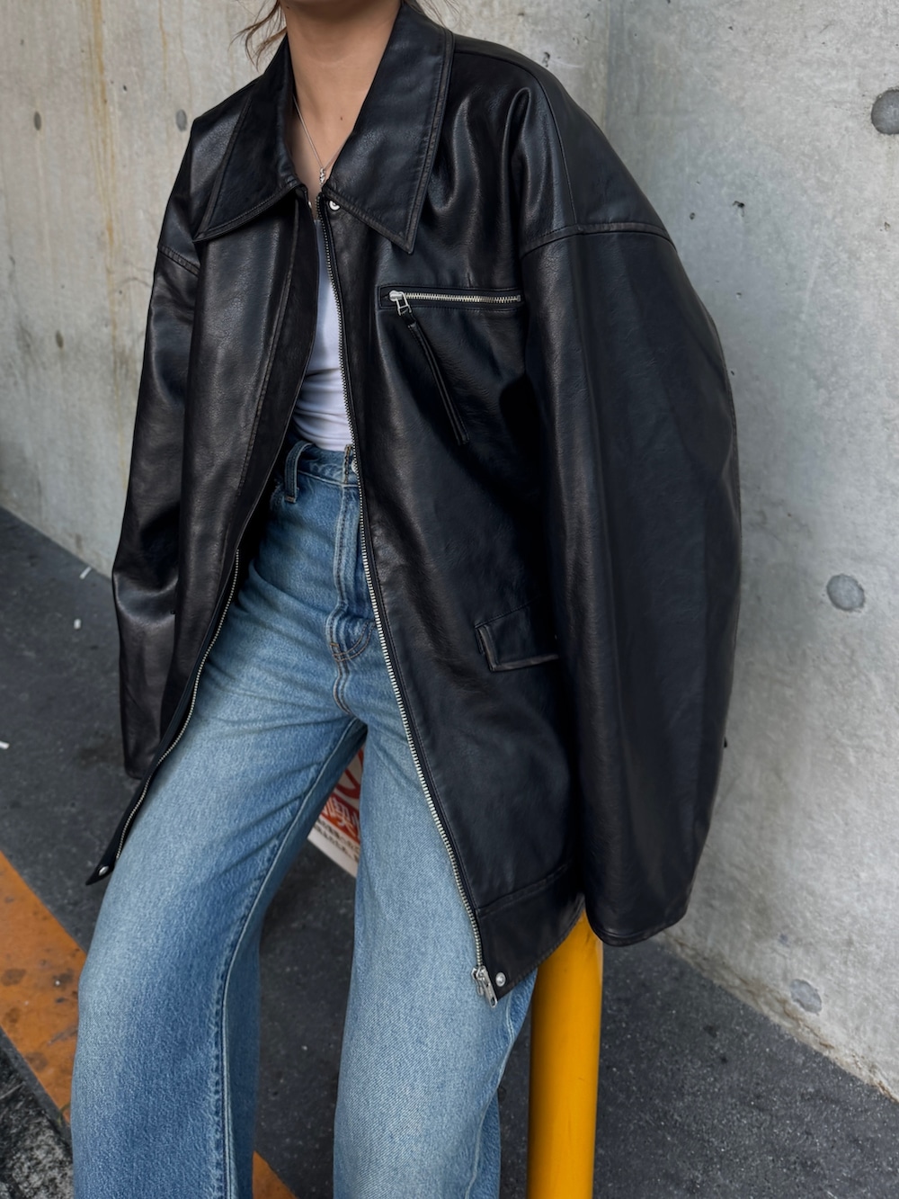 ブラック系のブルゾン、ブルー系のデニムパンツを着用したレディースの秋コーディネートの10枚目の写真