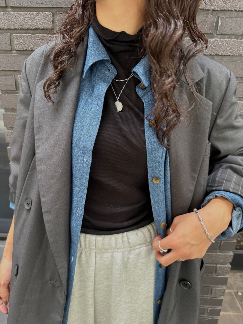 グレー系のスウェットパンツ、グレー系のテーラードジャケット、ブラック系のTシャツ/カットソーを着用したレディースの秋コーディネートの6枚目の写真