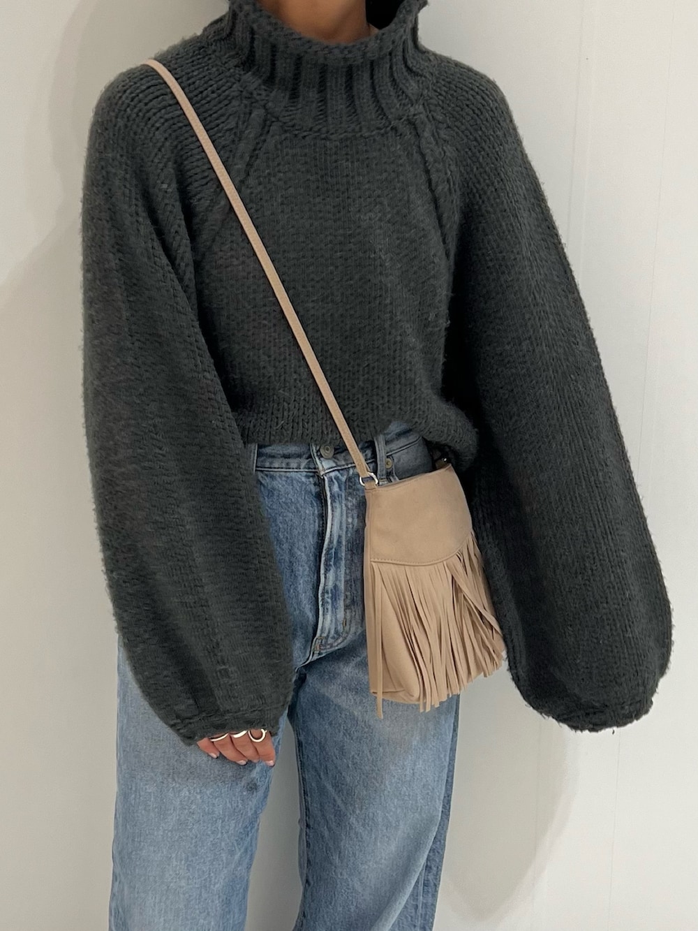 ブルー系のデニムパンツ、グレー系のニット/セーター、ベージュ系のブーツを着用したレディースの秋コーディネートの2枚目の写真