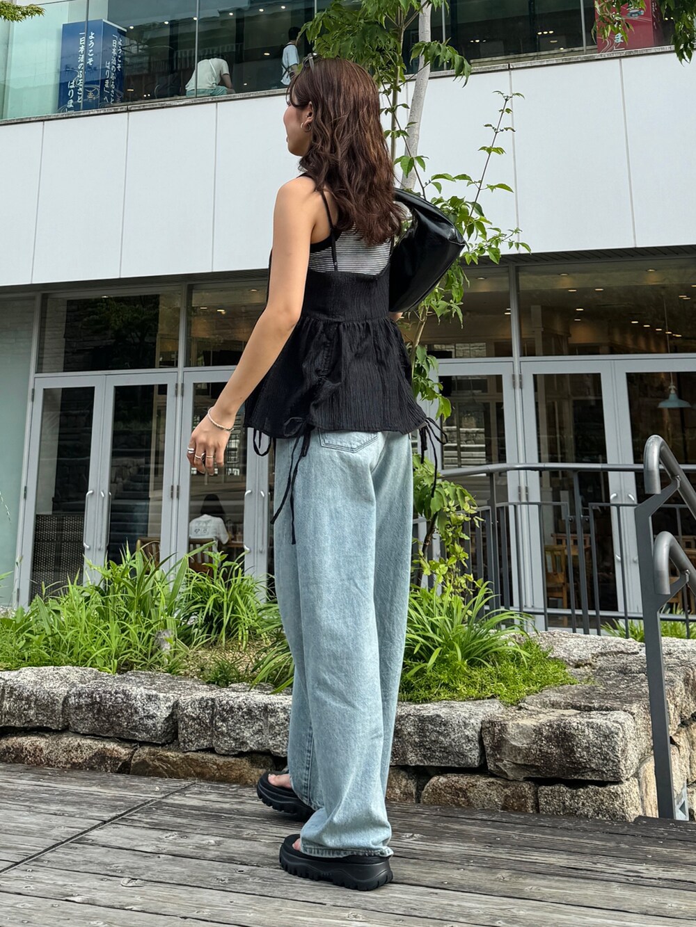 グレー系のタンクトップ、ブラック系のシャツ/ブラウス、ブルー系のデニムパンツを着用したレディースの夏コーディネートの3枚目の写真