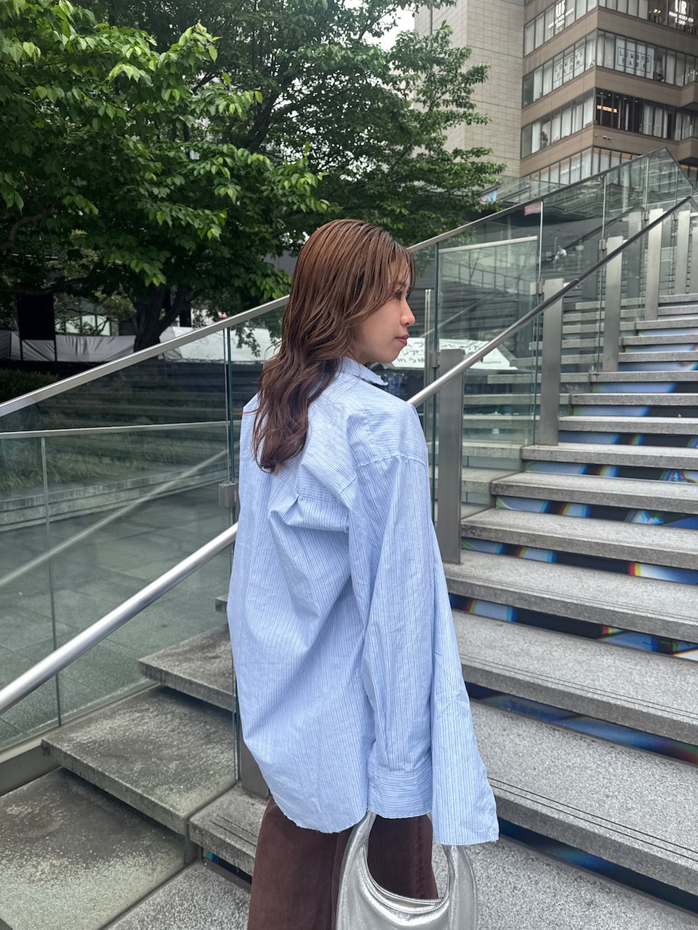 ブラウン系のデニムパンツ、ブルー系のシャツ/ブラウスを着用したレディースの春コーディネートの7枚目の写真