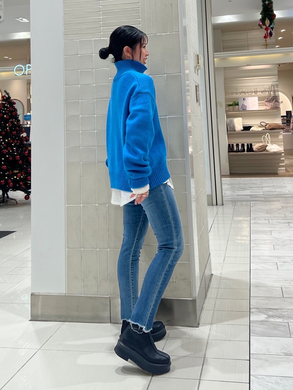 ブルー系のニット/セーター、ホワイト系のTシャツ/カットソー、ブラック系のブーツを着用したレディースの秋コーディネートの8枚目の写真