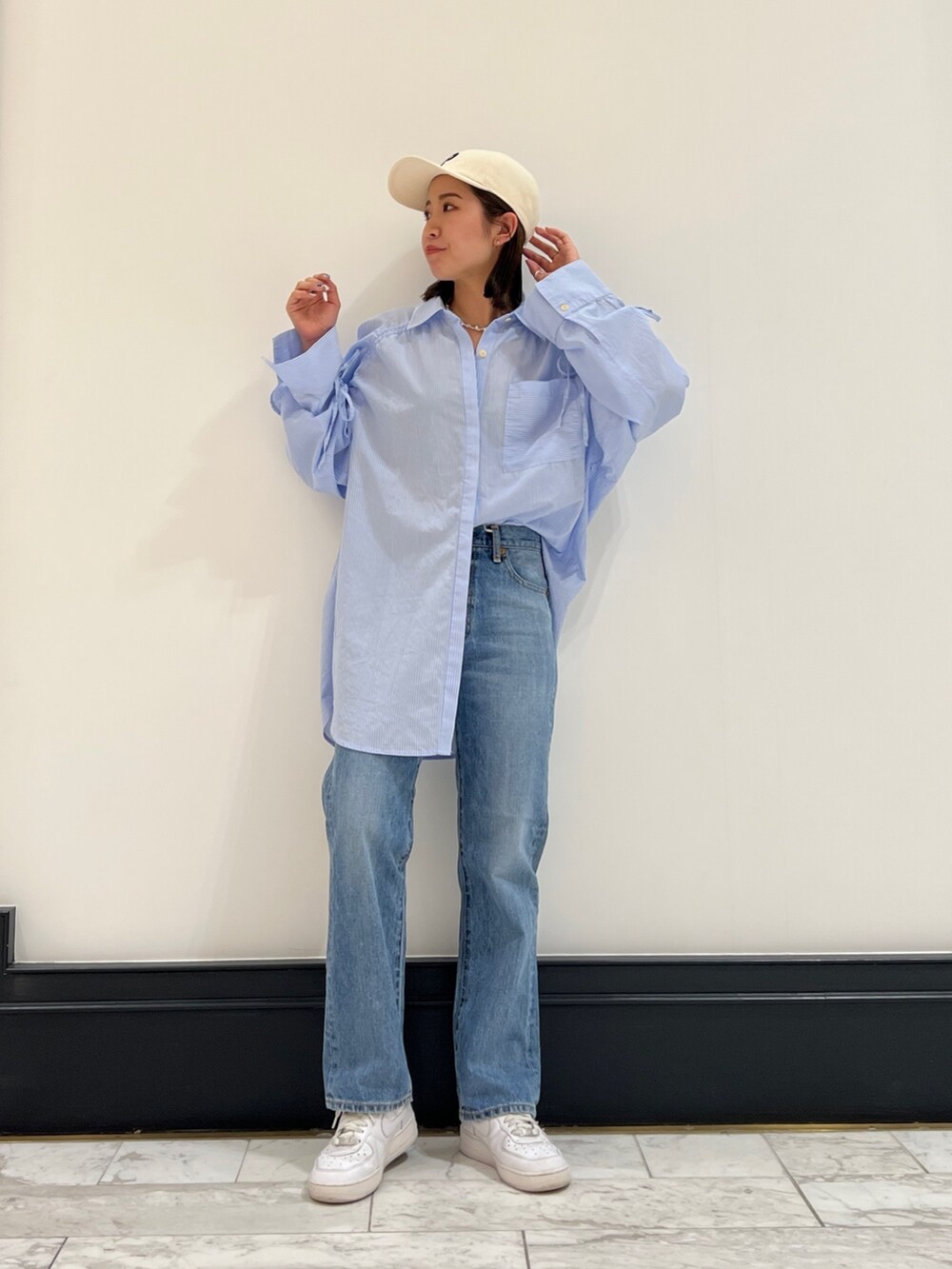 ブルー系のデニムパンツ、その他のシャツ/ブラウス、ホワイト系のキャップを着用したレディースの春コーディネートの4枚目の写真