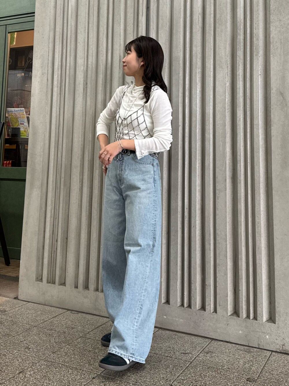 ブラック系のベスト、ブルー系のデニムパンツ、ホワイト系のTシャツ/カットソーを着用したレディースの冬コーディネートの6枚目の写真