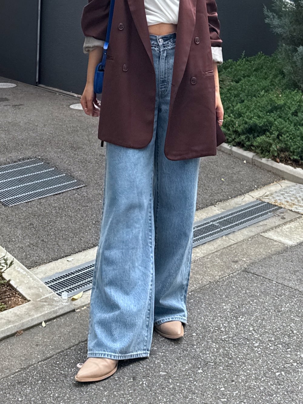 ブルー系のデニムパンツ、ブラウン系のテーラードジャケット、ホワイト系のTシャツ/カットソーを着用したレディースの夏コーディネートの9枚目の写真