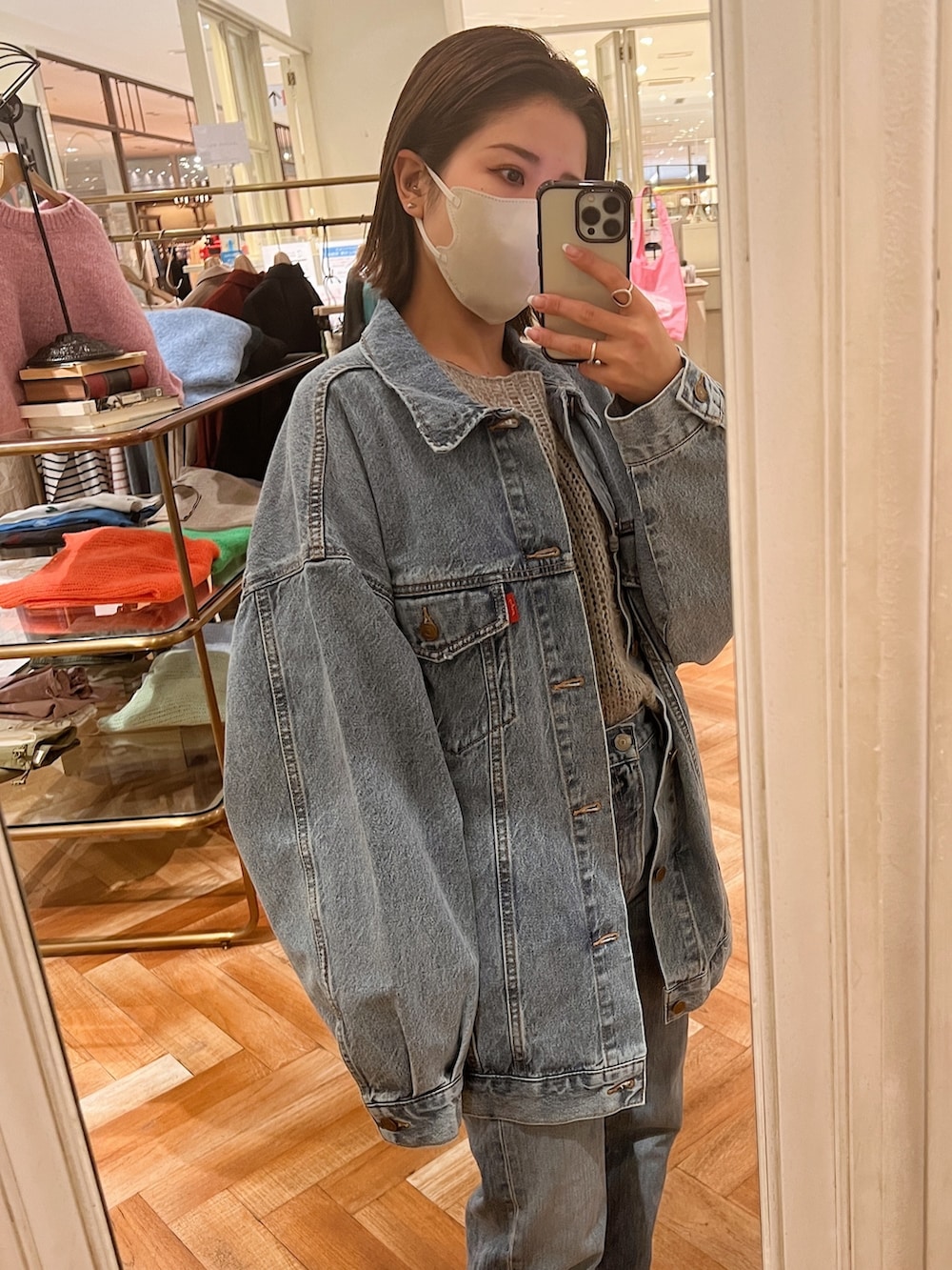 ホワイト系のデニムジャケット、グレー系のニット/セーター、ブルー系のデニムパンツを着用したレディースの冬コーディネートの3枚目の写真