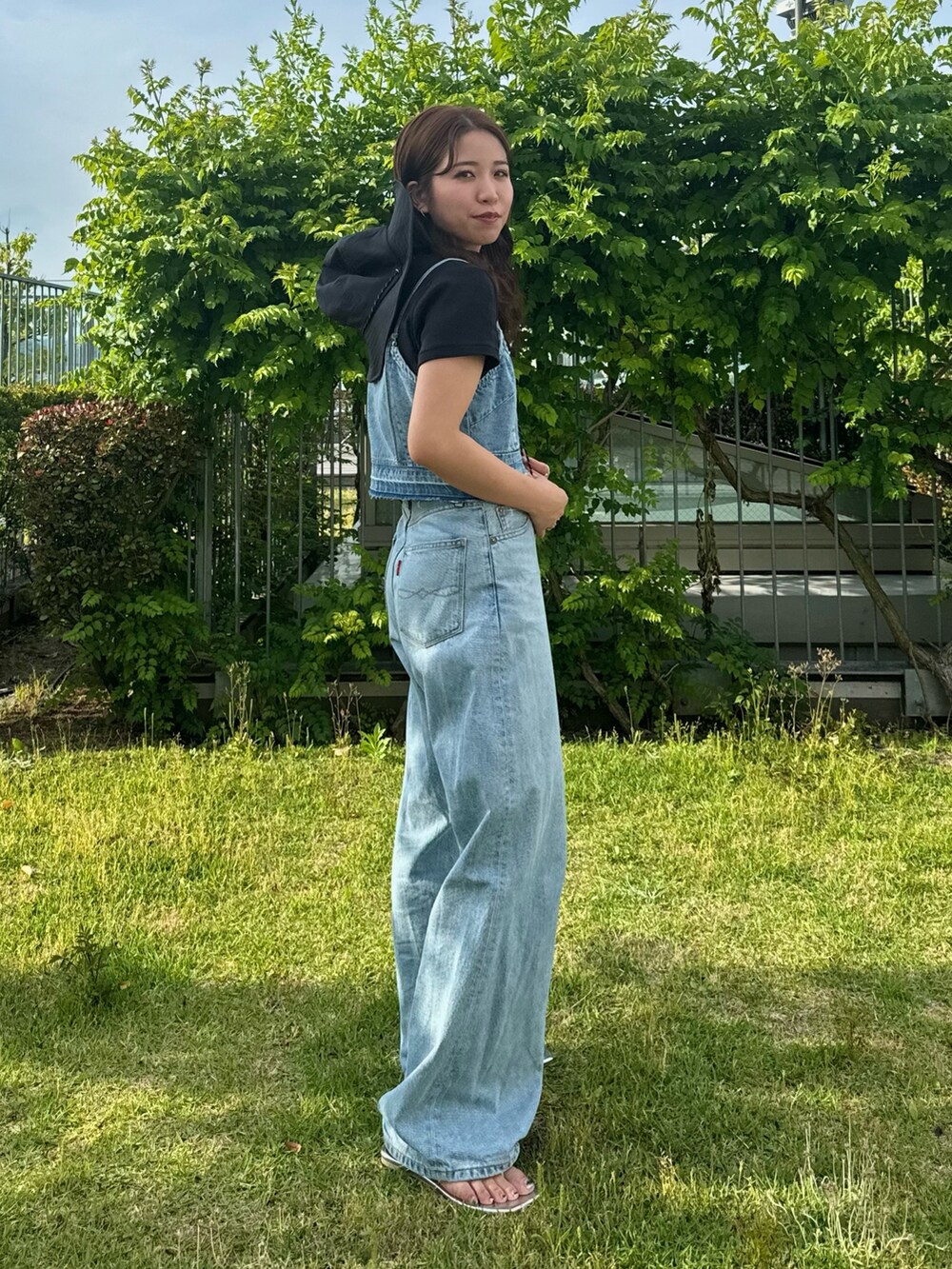 ブルー系のキャミソール、ブルー系のデニムパンツ、ブラック系のTシャツ/カットソーを着用したレディースの夏コーディネートの3枚目の写真