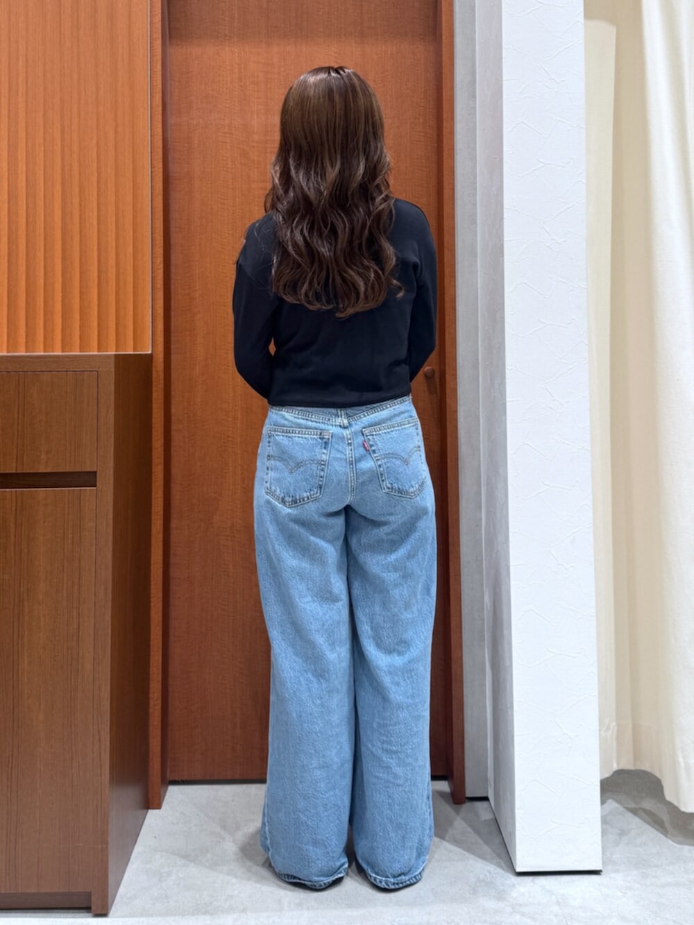 ブルー系のデニムパンツ、ブラック系のTシャツ/カットソー、シルバー系のネックレスを着用したレディースの夏コーディネートの3枚目の写真