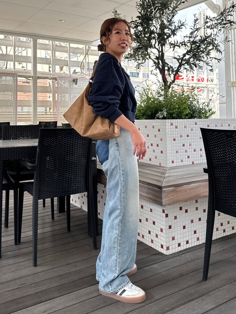 ブルー系のパーカー、ブルー系のデニムパンツ、シルバー系のネックレスを着用したレディースの冬コーディネートの5枚目の写真